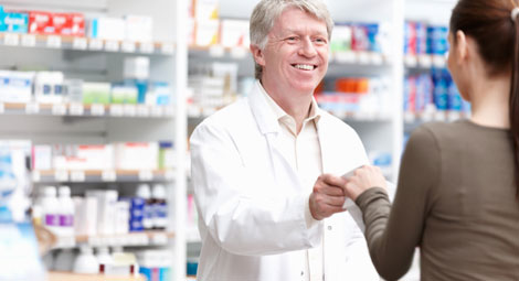 Male pharmacist issuing a prescription